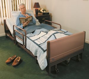 Elderly man lying in full-electric rental hospital bed.
